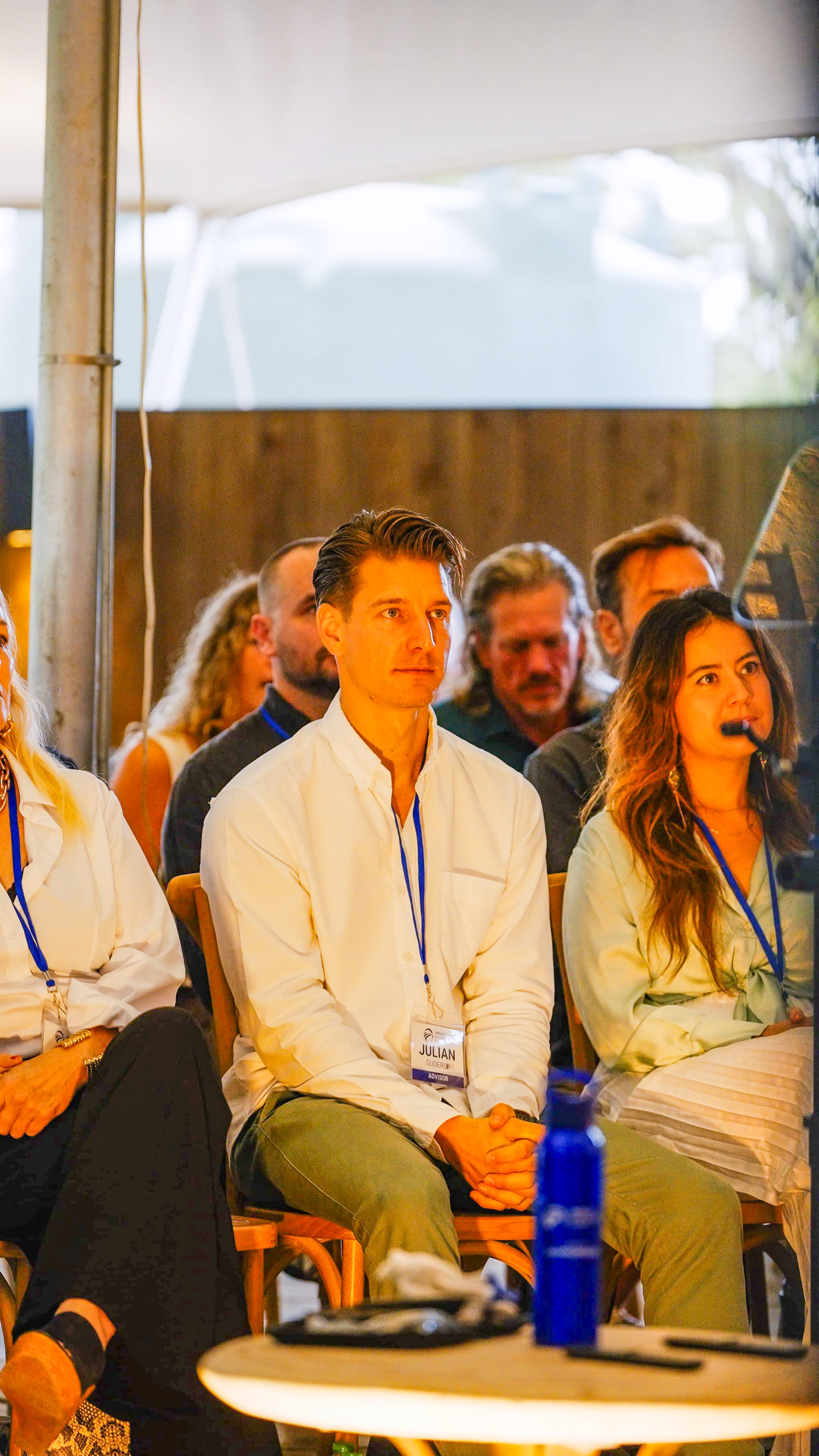 Audience members seated indoors attentively watching presentation
