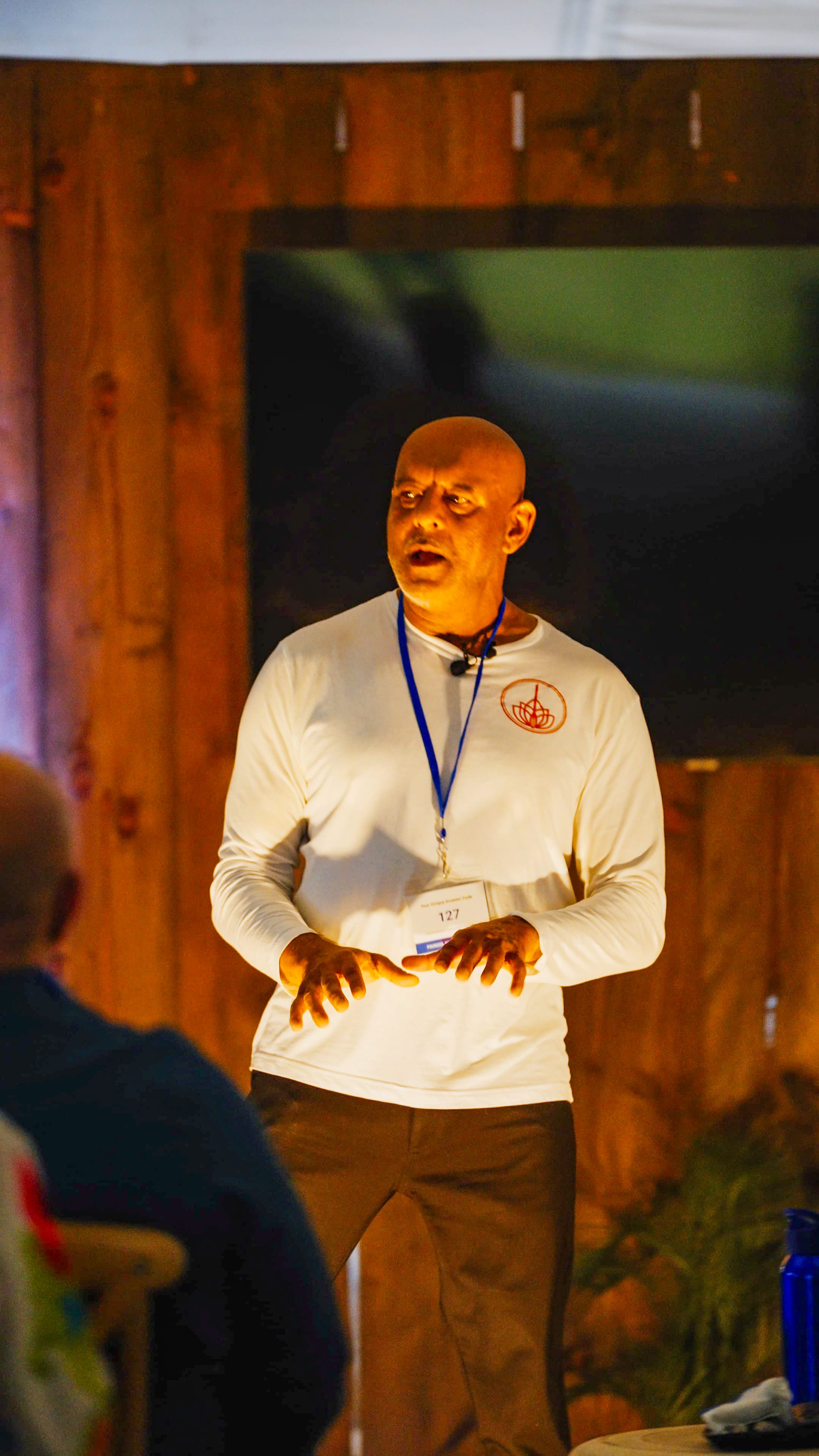Presenter teaching indoors with microphone headset and expressive hand gestures
