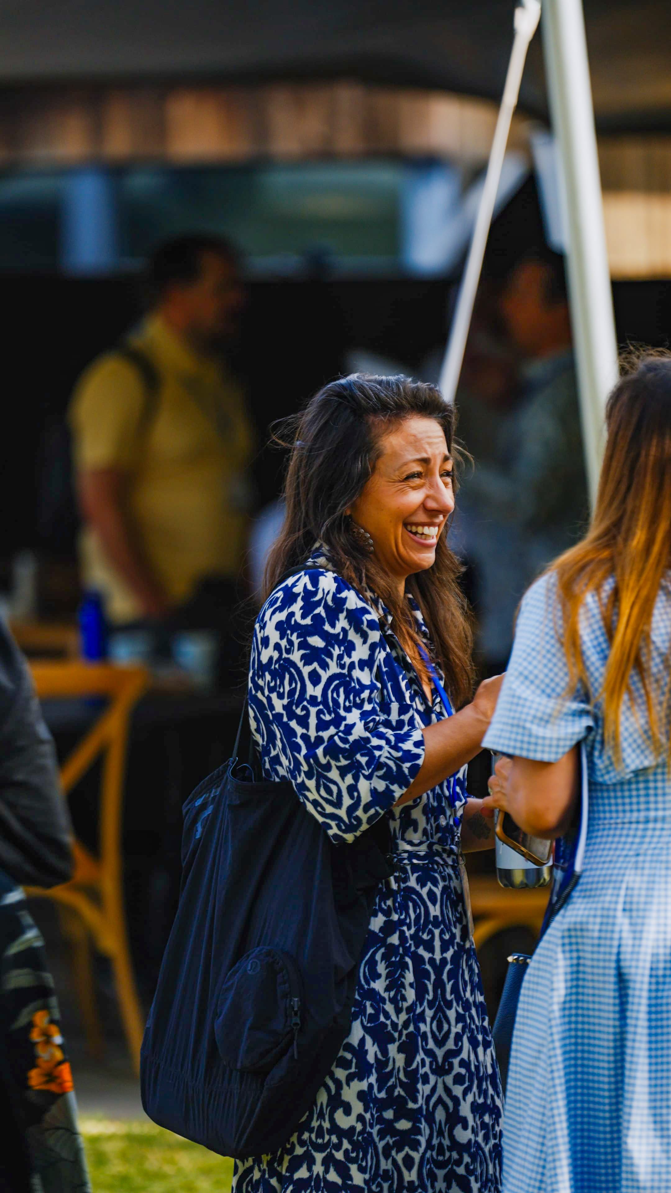 Female participant laughing joyfully in conversation with another participant indoors
