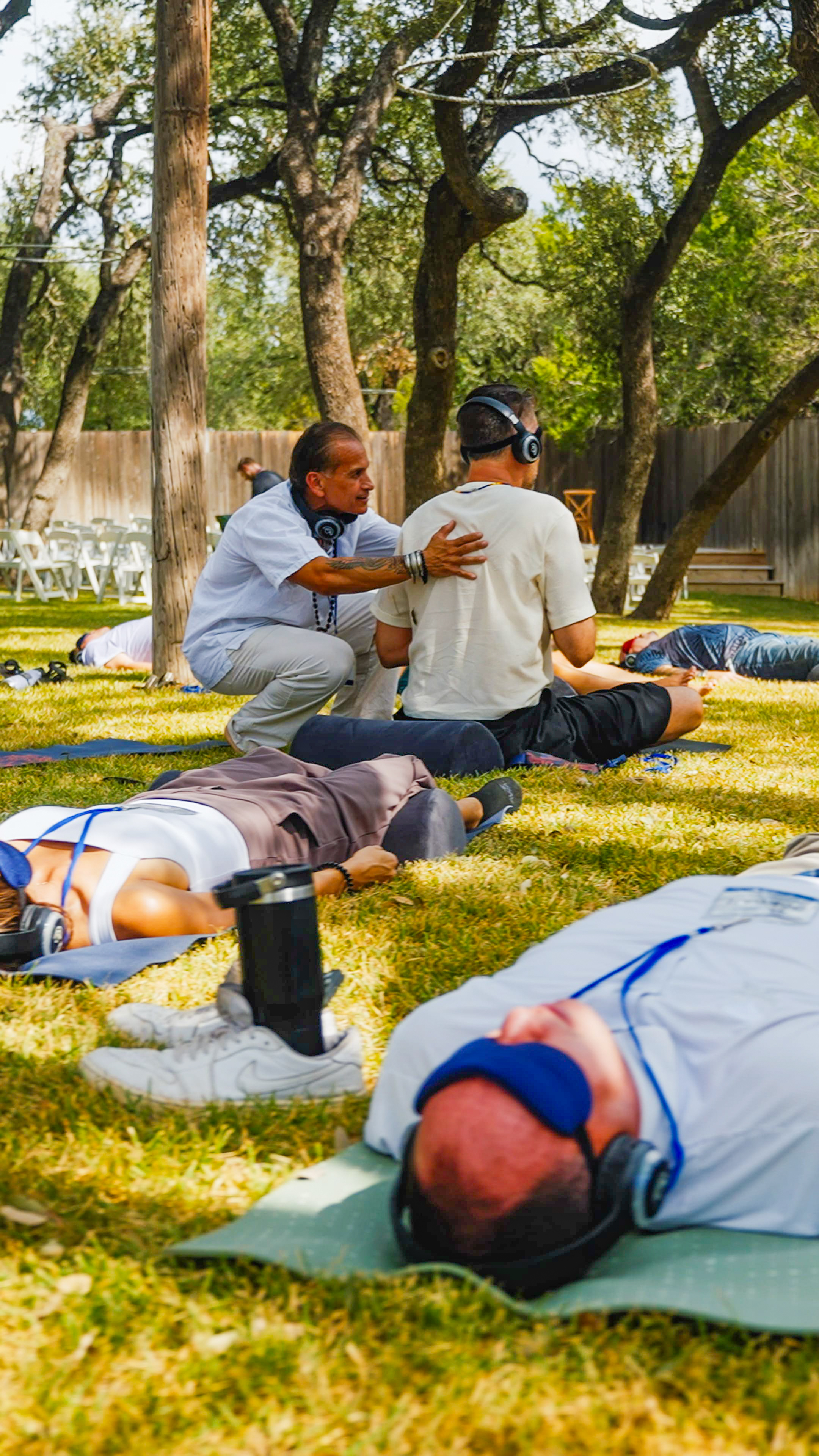 Participants in guided meditation or breathwork session outdoors on yoga mats